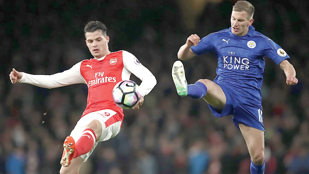 Granit Xhaka (trái, Arsenal) tranh bóng với Marc Albrighton (Leicester).