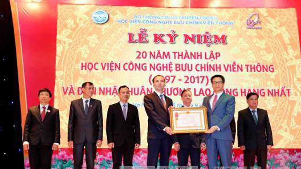 Phó Thủ tướng Vũ Đức Đam trao tặng Huân chương Lao động hạng Nhất của Chủ tịch nước cho Học viện Công nghệ Bưu chính Viễn thông. Ảnh: TTXVN