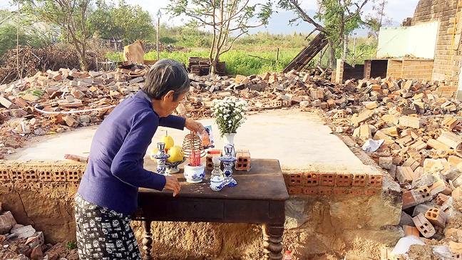 Căn nhà của chị Võ Thị Liên chỉ còn là đống gạch vụn. Cụ Lại (mẹ chị Liên) lập bàn thờ con giữa nền nhà trơ trọi