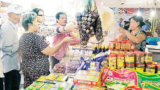 Khách tham quan mua đặc sản tỉnh Bến Tre. Ảnh: CAO THĂNG