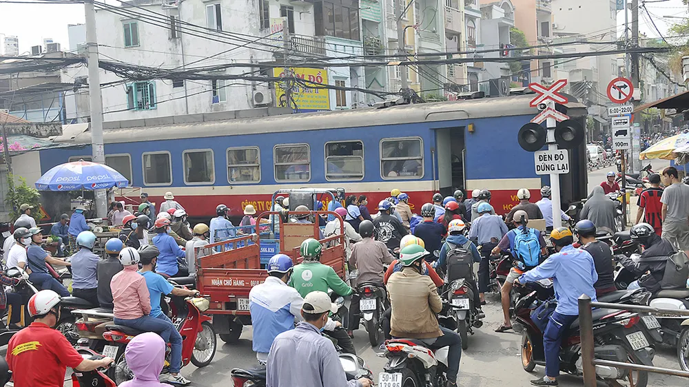 Phương tiện giao thông dừng lưu thông để xe lửa chạy qua Ảnh: thành trí