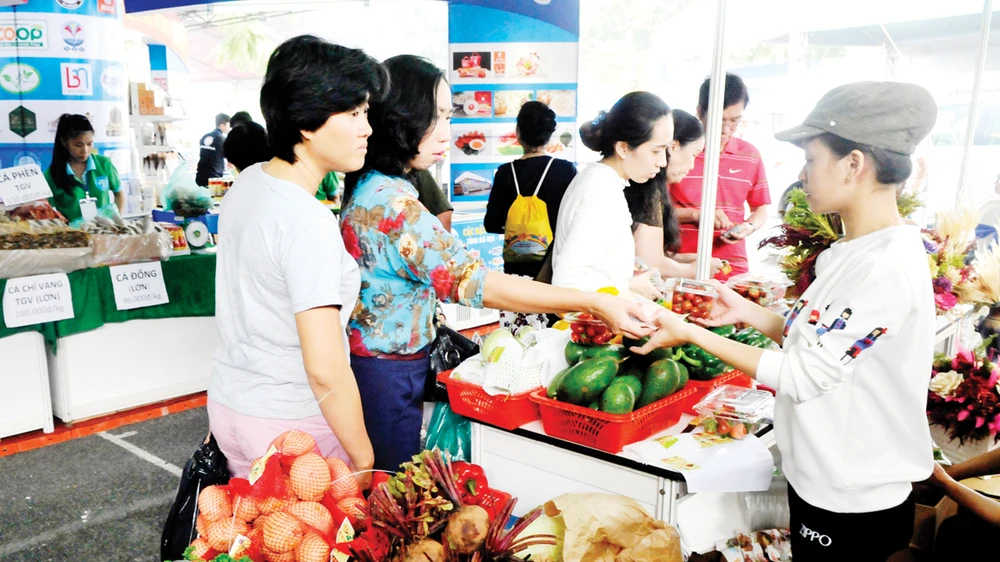 Người tiêu dùng mua rau củ quả tại gian hàng của tỉnh Lâm Đồng trong hội nghị Kết nối cung - cầu hàng hóa giữa TPHCM và các tỉnh, thành năm 2017 Ảnh: THÀNH TRÍ