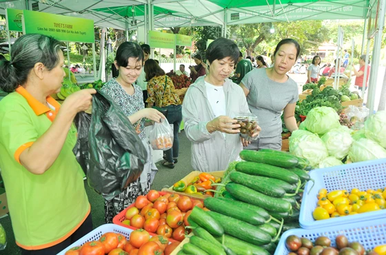 Người dân mua nông sản an toàn tại một chợ phiên. Ảnh: CAO THĂNG