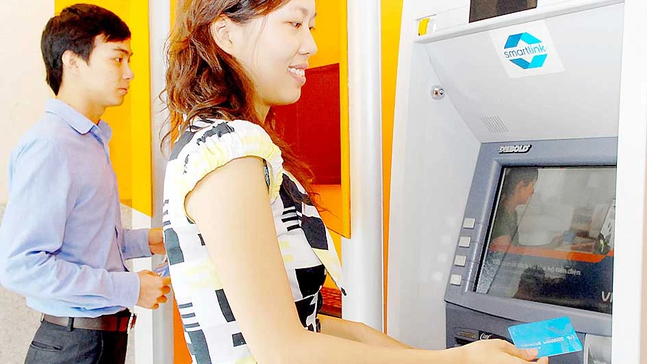 Khách hàng sử dụng thẻ ATM ngân hàng Ảnh: THÀNH TRÍ