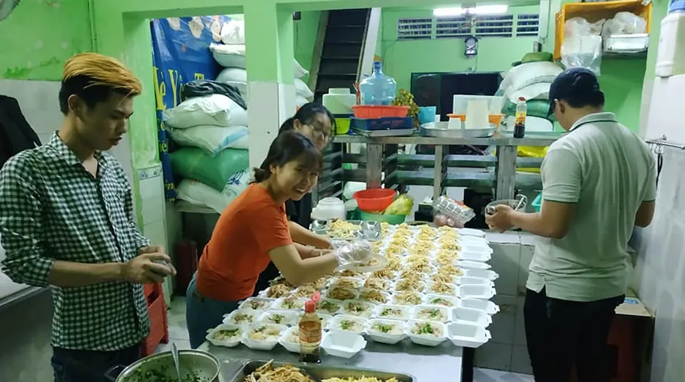 Nhóm bạn trẻ chuẩn bị những phần xôi mặn để phát vào buổi tối