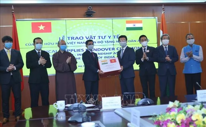 Bộ trưởng Bộ Thông tin và Truyền thông Nguyễn Mạnh Hùng, Chủ tịch Hội Hữu Việt Nam - Ấn Độ trao vật tư y tế cho Đại sứ Ấn Độ tại Việt Nam Pranay Verma. Ảnh:TTXVN
