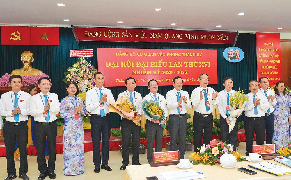 Bí thư Thành ủy TPHCM Nguyễn Thiện Nhân, Phó Bí thư Thường trực Thành ủy TPHCM Trần Lưu Quang tặng hoa chúc mừng Ban Chấp hành Đảng bộ Cơ quan Văn phòng Thành ủy. Ảnh: VIỆT DŨNG