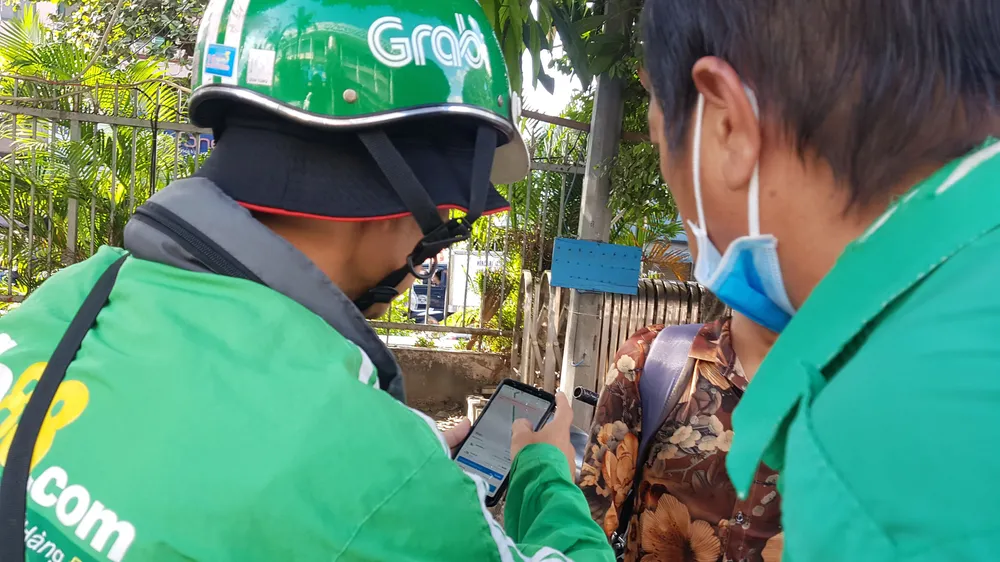 Một đối tượng giả danh GrabBike đứng đón khách tại Bến xe miền Đông (quận Bình Thạnh, TPHCM)