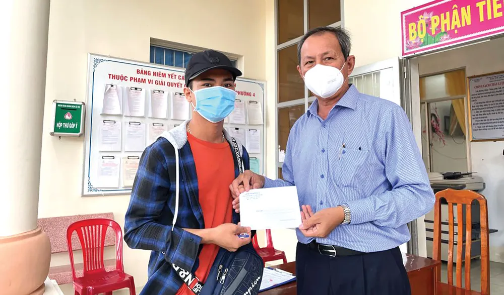 Ông Lưu Hoàng Tân-Chủ tịch kiêm Giám đốc Công ty TNHH MTV Xổ số kiến thiết tỉnh Đồng Tháp trao tiền cho người bán vé số dạo tại tỉnh