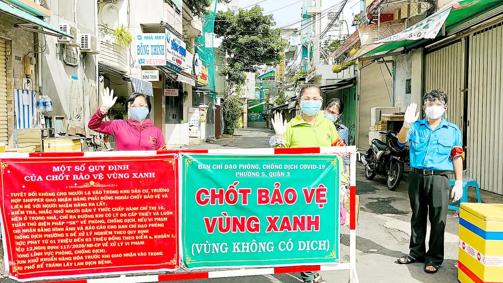 Nhân dân tự nguyện tham gia trực chốt tự quản bảo vệ “vùng xanh” ở quận 3. Ảnh: VĂN MINH