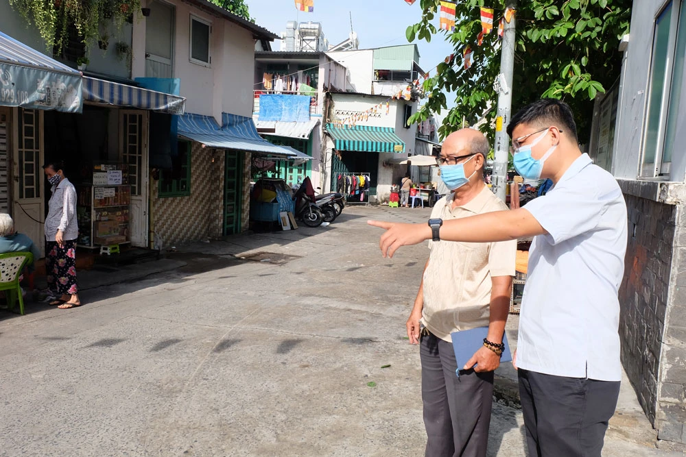 Bí thư Chi bộ khu phố 3, phường 9 (quận 4) Tiêu Quang và cán bộ phụ trách đô thị phường 9 khảo sát tình hình trật tự lòng lề đường