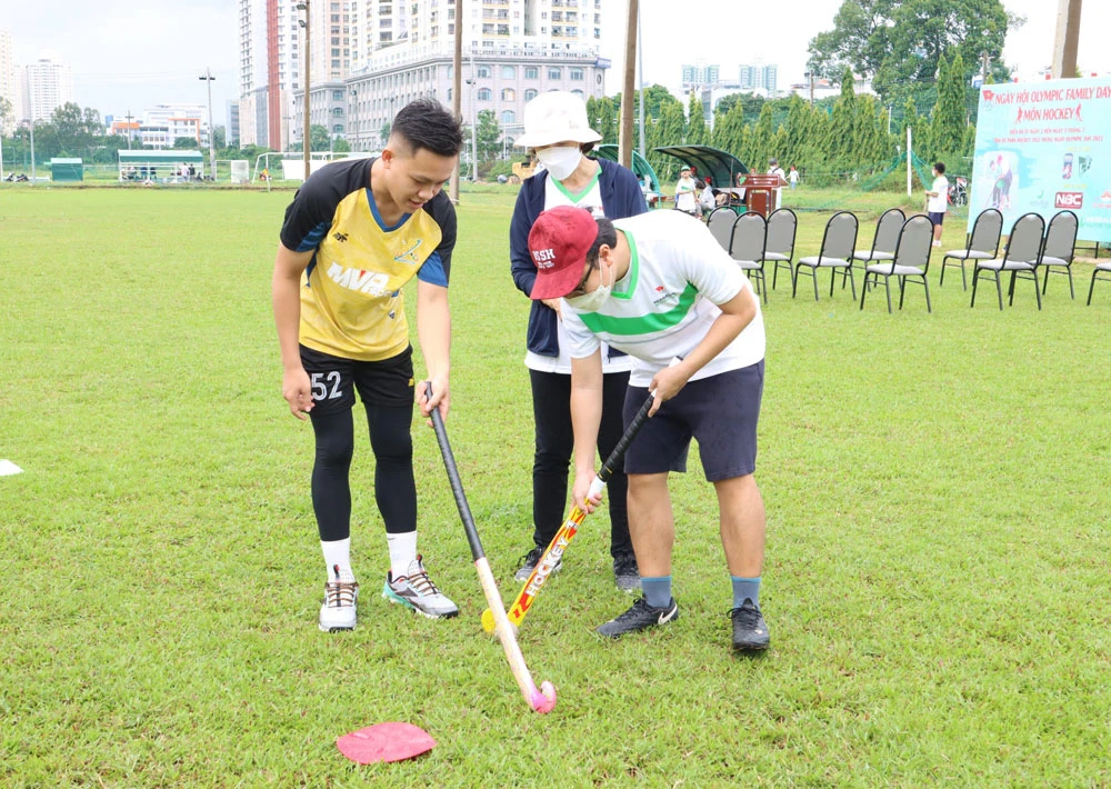 Huấn luyện viên hướng dẫn các kỹ thuật cơ bản trong bộ môn hockey cho các trẻ đặc biệt và phụ huynh. Ảnh: NGUYỄN ANH