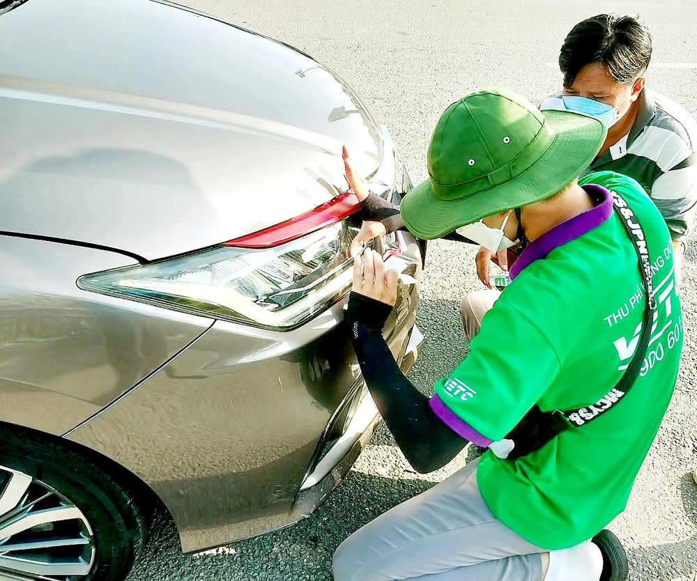 Nhiều tài xế phải dừng xe trên đường cao tốc để dán thẻ thu phí tự động. Ảnh: HOÀNG BẮC