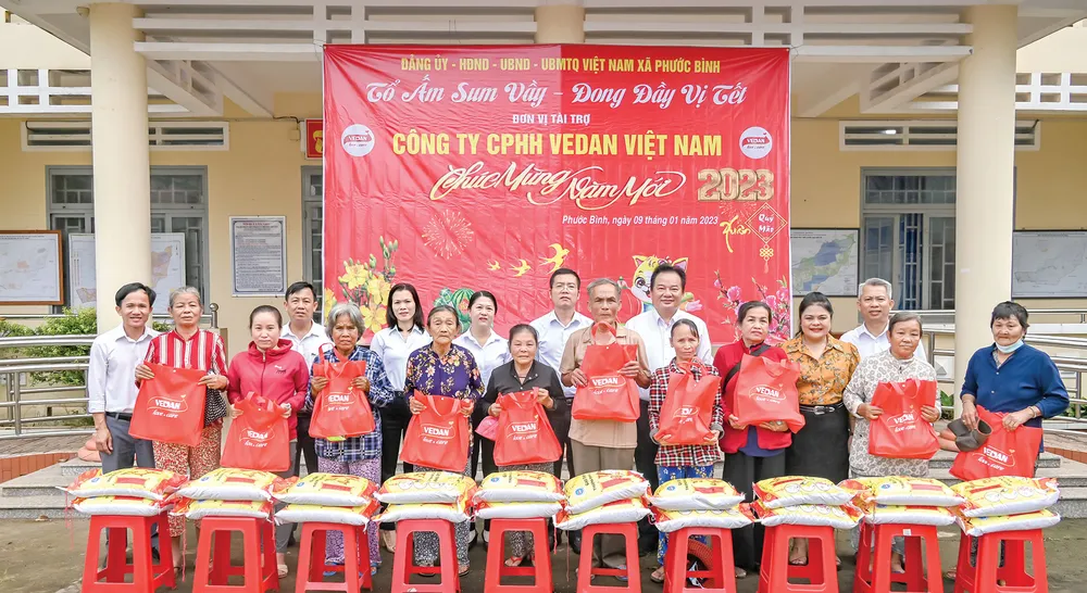 Bà Nguyễn Thu Thuỷ - Phó Giám đốc Đối ngoại Vedan Việt Nam (áo cam) đến trao quà Tết cho người dân tại xã Phước Bình