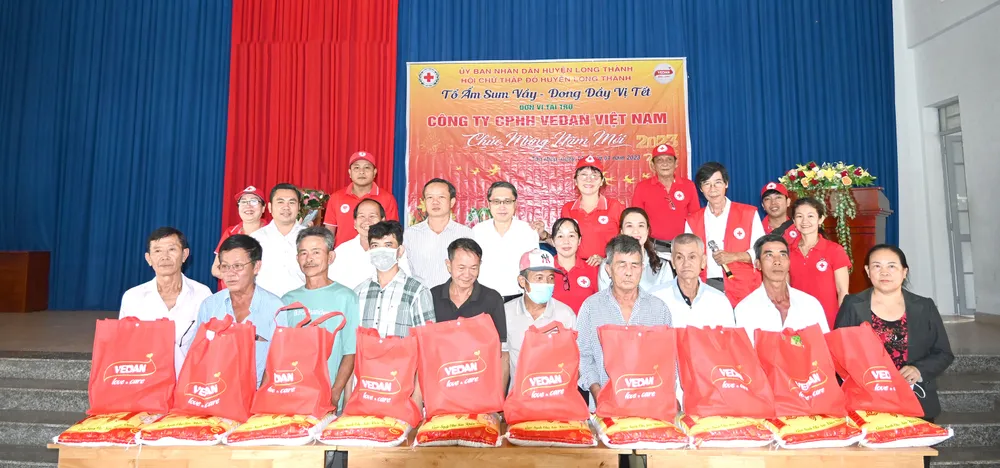 Ông Ni Chih Hao - Tổng Giám đốc Công ty CPHH Vedan Việt Nam (áo trắng, đứng giữa) cùng Hội Chữ thập đỏ huyện Long Thành trao quà Tết cho bà con tại xã Tân Hiệp, huyện Long Thành