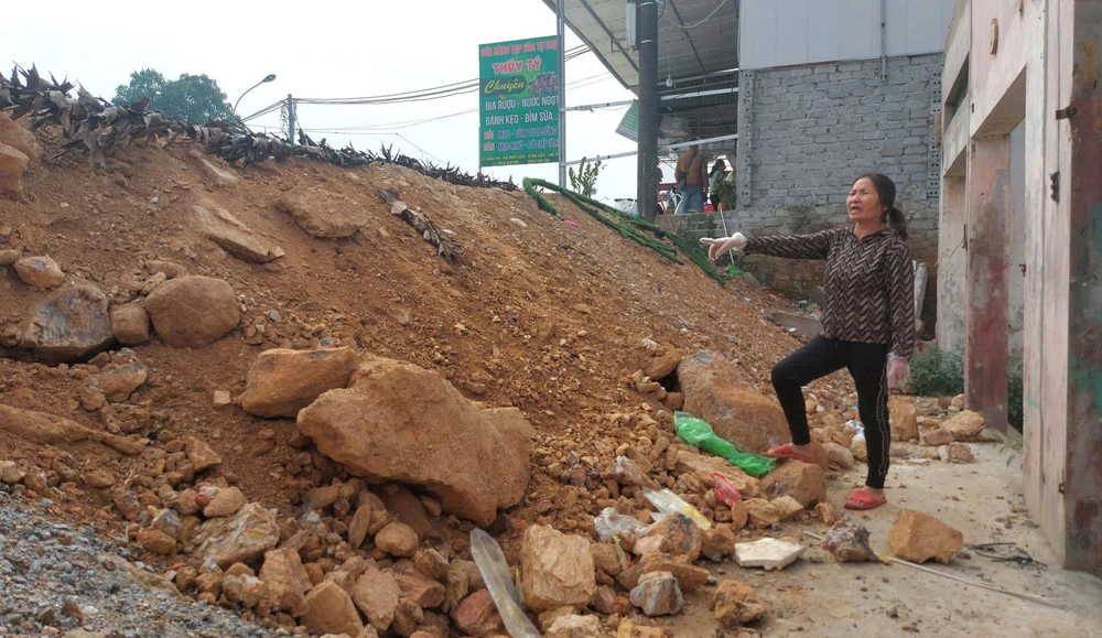 Bà Trần Thị Thanh (thôn Tân Tiến, Phú Lộc, Can Lộc, Hà Tĩnh) bên đường cao hơn nhà. Ảnh: DƯƠNG QUANG