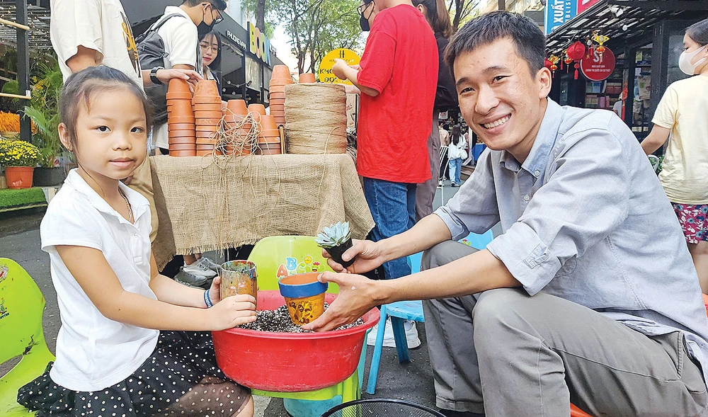 Bùi Hoàng Huy hướng dẫn trồng cây cho một em nhỏ tại chương trình “Khu vườn ước mơ”