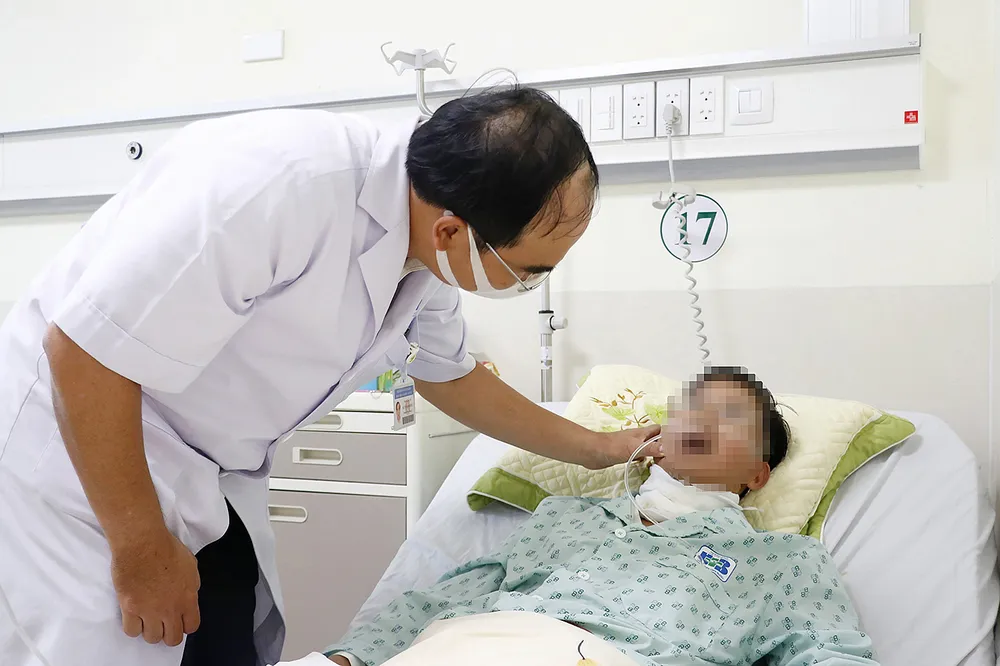 TS-BS Nguyễn Anh Khôi thăm khám bệnh nhân sau phẫu thuật. Ảnh: NGÔ BÌNH