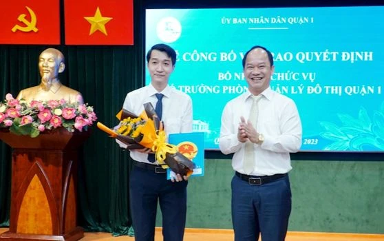 Chủ tịch UBND quận 1 Lê Đức Thanh trao quyết định bổ nhiệm chức danh Phó Trưởng Phòng Quản lý đô thị quận cho ông Dương Thanh Bình - người trúng tuyển kỳ thi chức danh lãnh đạo, quản lý cấp phòng do UBND quận 1 tổ chức