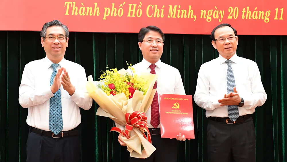 Bí thư Thành ủy TPHCM Nguyễn Văn Nên và Phó Bí thư Thành ủy TPHCM Nguyễn Phước Lộc trao quyết định và tặng hoa chúc mừng đồng chí Phạm Hồng Sơn. Ảnh: VIỆT DŨNG