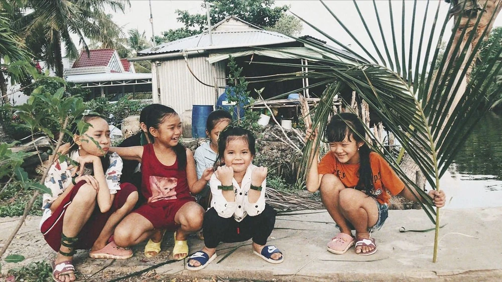 Sắp nhỏ khoe những món đồ chơi làm bằng lá dừa. Ảnh: ĐỖ TÌNH