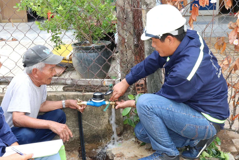 Ông Nguyễn Văn Tới (trái), ngụ tổ 4, ấp An Hòa, xã Tam Thôn Hiệp (huyện Cần Giờ) trong niềm vui được gắn đồng hồ nước thông minh