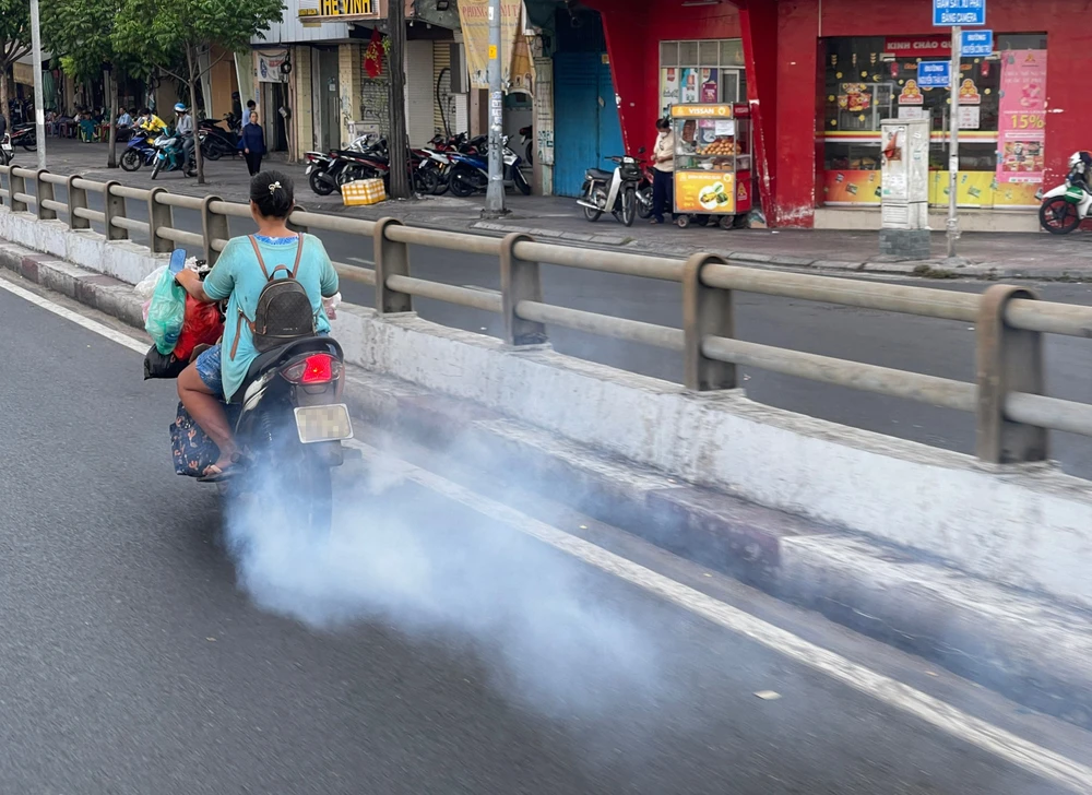 Xe máy xả khói mù mịt gây ô nhiễm môi trường. (Ảnh chụp trên đường Nguyễn Thái Học, quận 1, TPHCM). Ảnh: HOÀNG HÙNG