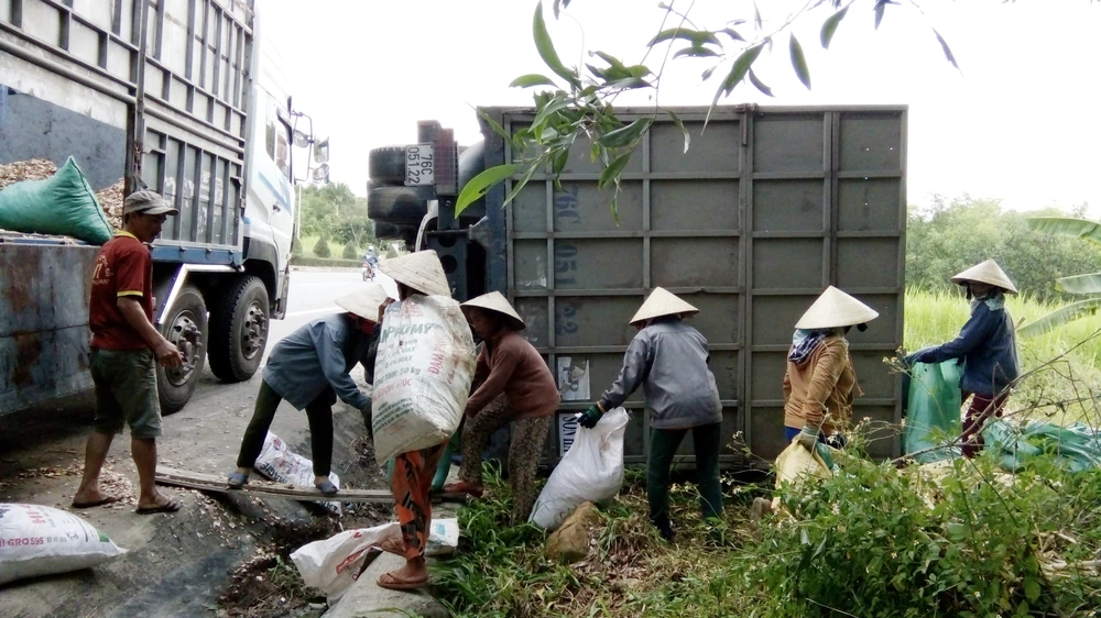 Người dân thu dọn dăm gỗ giúp tài xế vận chuyển sang xe trung chuyển. Ảnh:NGUYỄN TRANG