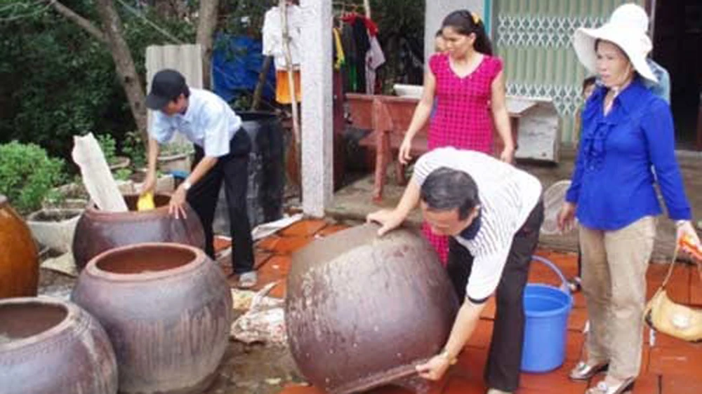 Làm vệ sinh lu chứa nước ngừa loăng quăng. Ảnh minh họa