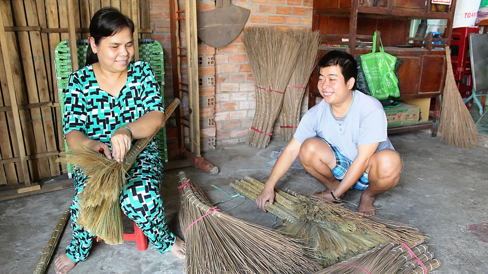 Chị Lam đang hướng dẫn cho một người đồng cảnh ngộ cách làm chổi 