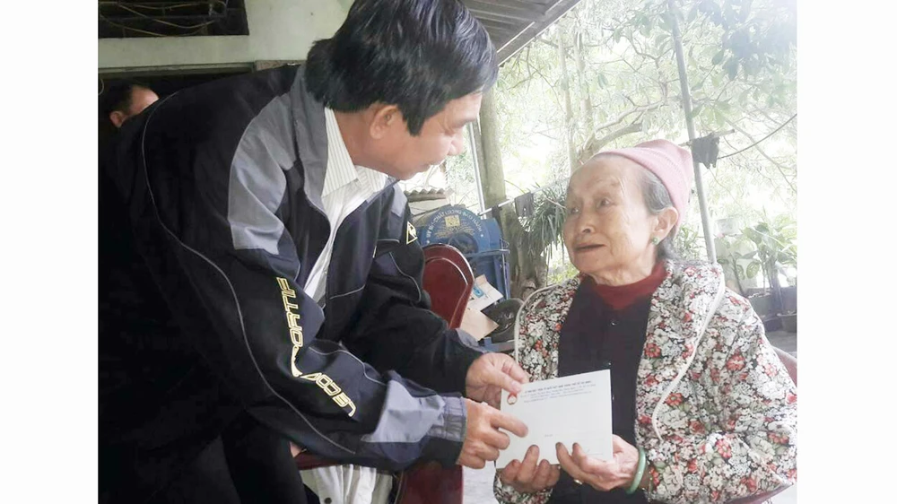 Ông Đỗ Trung Tính trao tiền hỗ trợ bà Nguyễn Thị Hường (ở tỉnh Hòa Bình, có người thân bị lũ cuốn trôi)