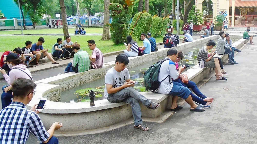 Hình ảnh các nhóm bạn trẻ cùng ngồi bên nhau nhưng không ai  nói chuyện với ai, chỉ “ôm” ĐTDĐ đã trở nên quen thuộc. Ảnh: ĐOÀN HIỆP