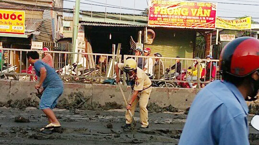 Hình ảnh đẹp của CSGT TPHCM thu dọn bùn đất rơi trên đường phố ảnh 1