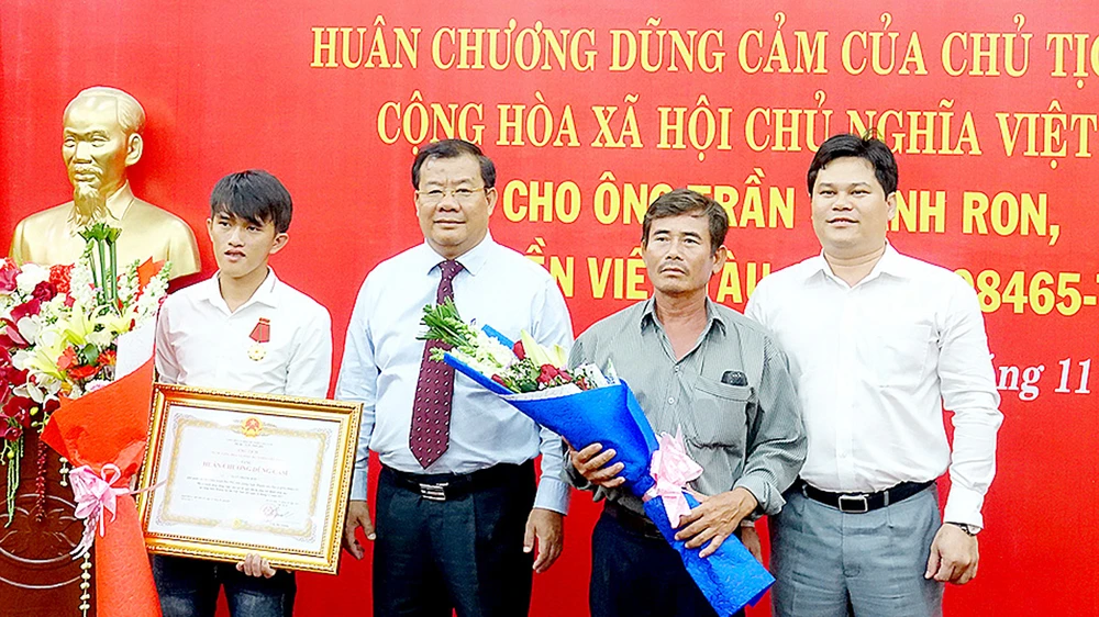 Lãnh đạo tỉnh Quảng Ngãi trao Huân chương Dũng cảm của Chủ tịch nước tặng thưởng anh Trần Thanh Ron (bìa trái)