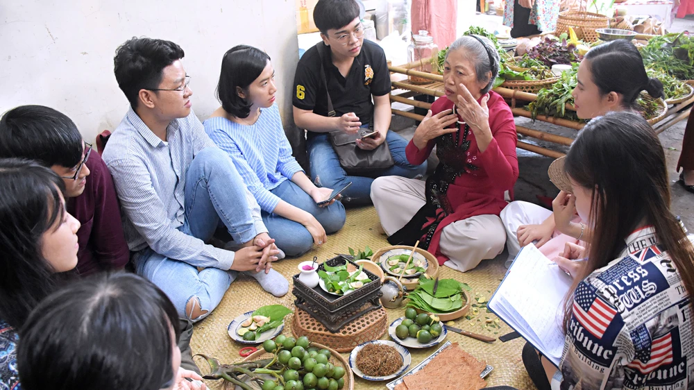  Các bạn trẻ lắng nghe chia sẻ về văn hóa trầu cau từ lớp người đi trước