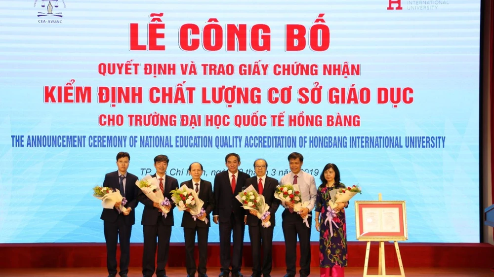 NGND.PGS.TS Hồ Thanh Phong – Hiệu trưởng ĐH HIU (giữa) tặng hoa cảm ơn đại diện Cục Quản lý chất lượng, TT KĐCLGD, Tập đoàn Giáo dục Nguyễn Hoàng đến tham dự sự kiện