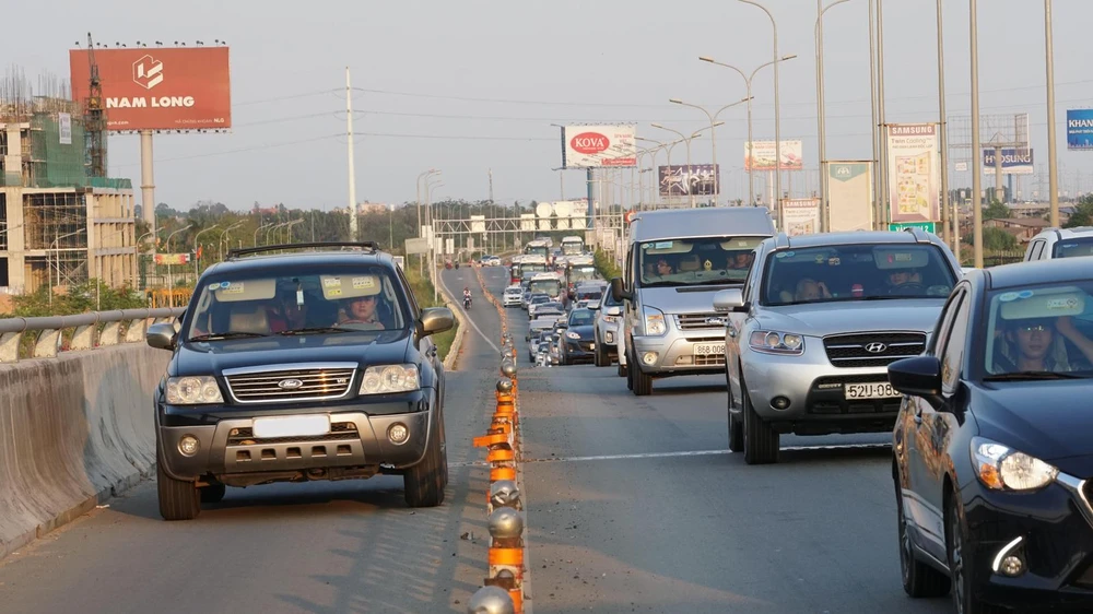 Ô tô đi vào làn đường xe máy trên đường dẫn cao tốc TPHCM - Long Thành. Ảnh: HOÀNG HÙNG