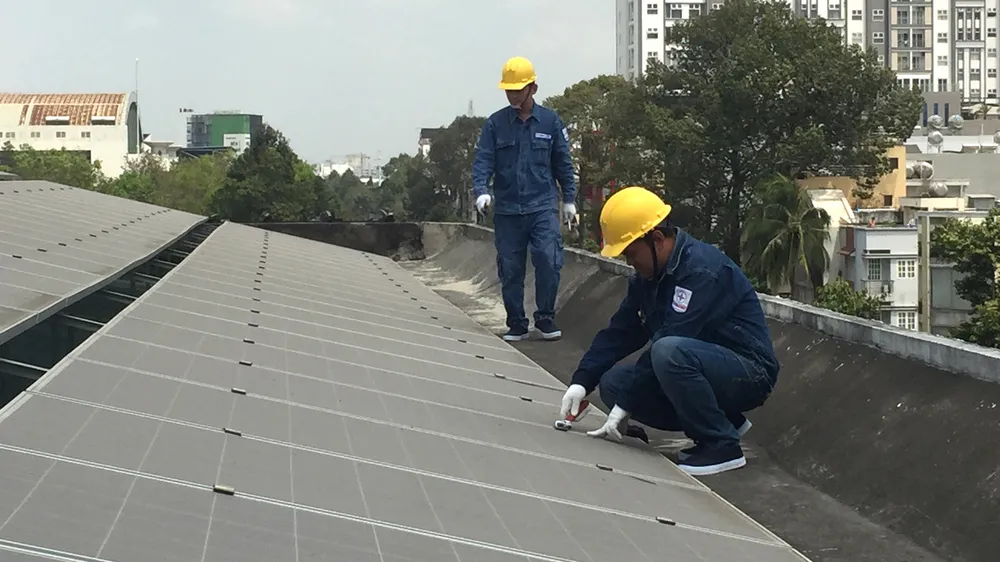 Nhân viên ngành điện lắp đặt điện mặt trời áp mái cho một đơn vị trên địa bàn TPHCM