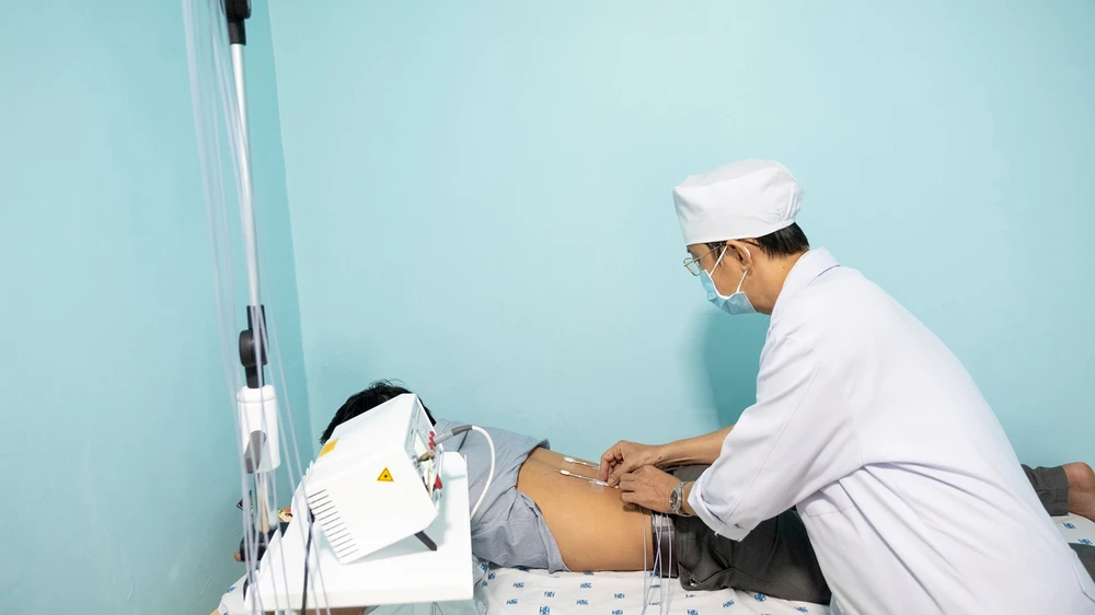 Bác sĩ xác định huyệt để thực hiện phương pháp laser châm