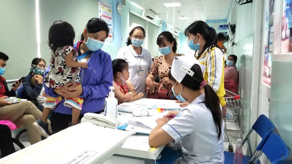 Phụ huynh bồng bế trẻ chờ thăm khám tại Khoa Hô hấp Bệnh viện Nhi đồng 1 sáng 27-10