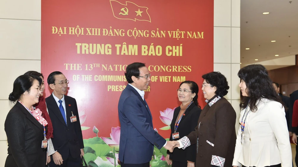 Bí thư Thành ủy TPHCM Nguyễn Văn Nên trao đổi cùng các đại biểu đoàn TPHCM tại Đại hội XIII của Đảng trong ngày 29-1. Ảnh VIẾT CHUNG