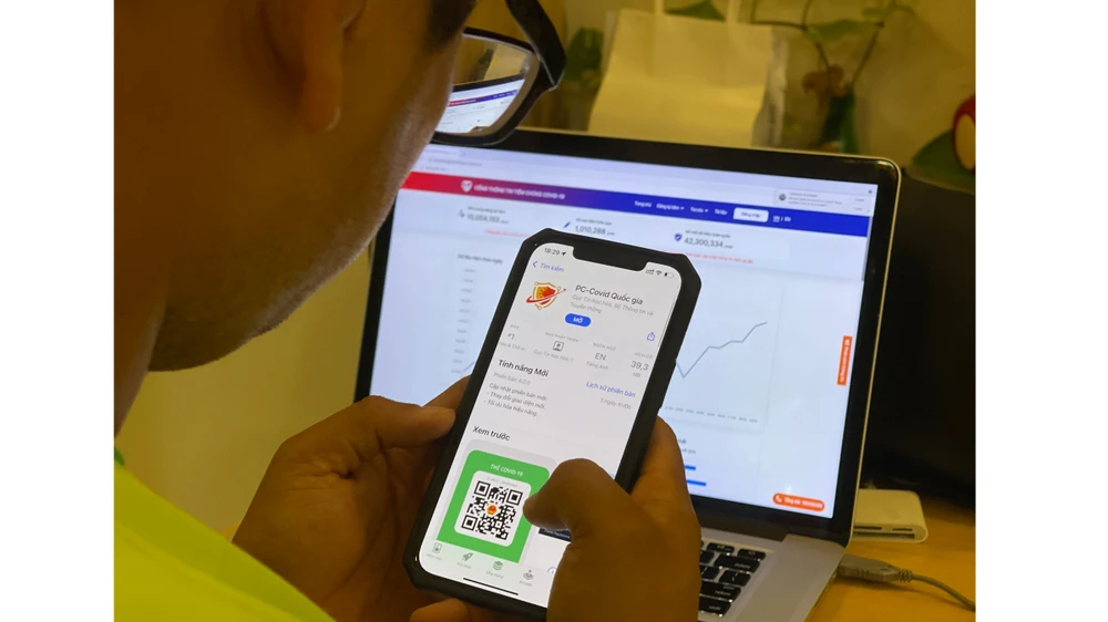 Người dân tìm hiểu ứng dụng PC-Covid. Ảnh: HOÀNG HÙNG
