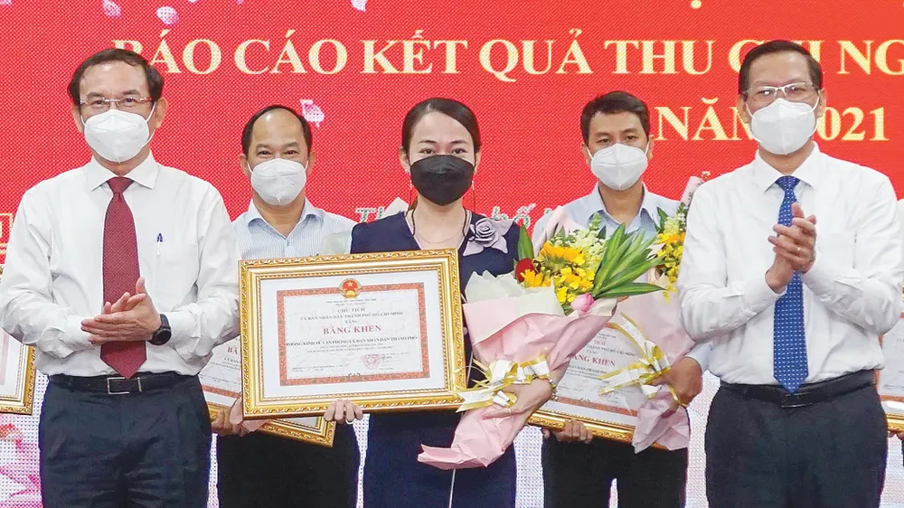 Bí thư Thành ủy TPHCM Nguyễn Văn Nên và Chủ tịch UBND TPHCM Phan Văn Mãi trao bằng khen của UBND TP cho các đơn vị đạt thành tích cao trong công tác thu ngân sách năm 2021. Ảnh: HOÀNG HÙNG