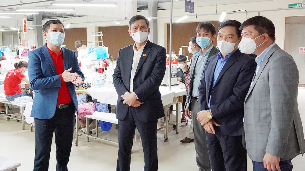Ông Trần Thắng, Chủ tịch UBND tỉnh Quảng Bình (thứ 2, trái qua) thăm hỏi một cơ sở may công nghiệp trên địa bàn
