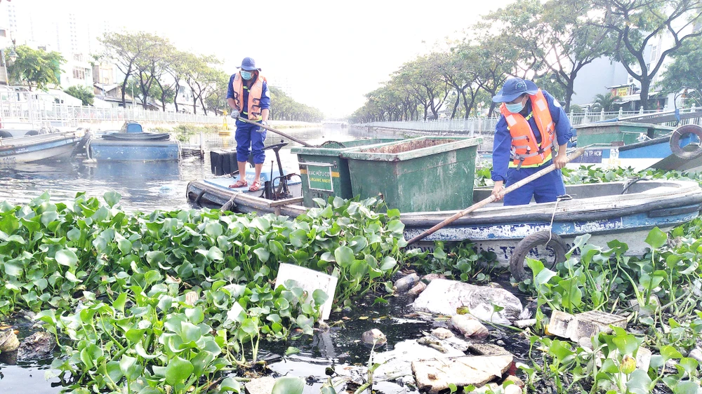 Công nhân Công ty Môi trường đô thị TPHCM vớt rác trên tuyến kênh Tân Hóa - Lò Gốm