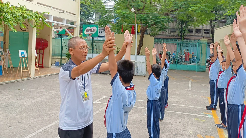 Thầy Hồ Xuân Hùng, giáo viên Trường Tiểu học Phú Thọ (quận 11), tận tình chỉ dẫn học sinh trong từng động tác