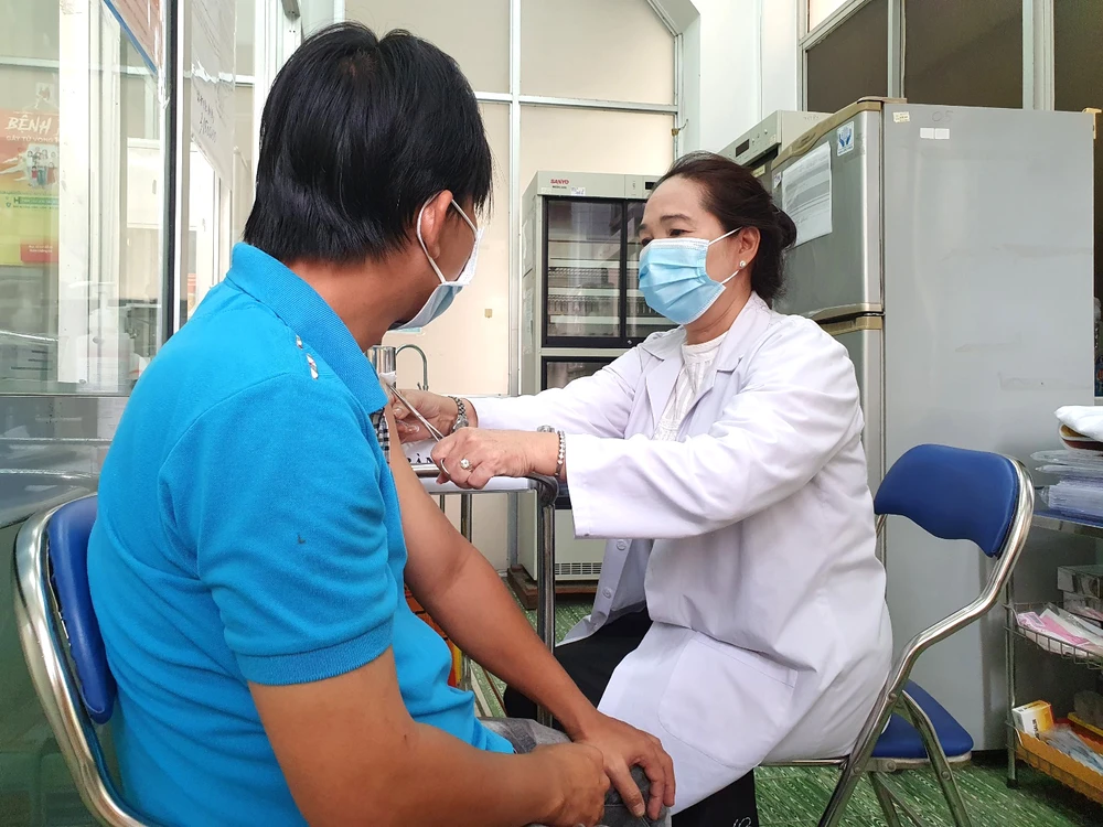 Nhân viên Trung tâm Y tế Quận 8 (TPHCM) tiêm vaccine Covid-19 cho người dân. Ảnh: THÀNH SƠN