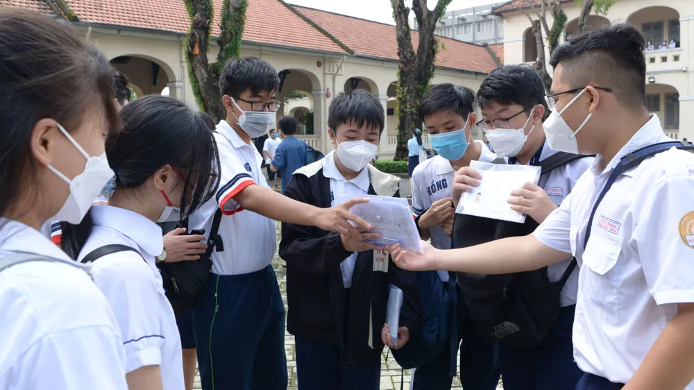 Học sinh thi lớp 10 năm học 2022-2023 tại điểm thi Trường THPT Chuyên Lê Hồng Phong trao đổi bài vở . Ảnh: CAO THĂNG