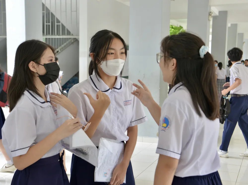 Thí sinh trao đổi sau giờ thi môn Ngữ văn sáng 6-6. Ảnh: CAO THĂNG