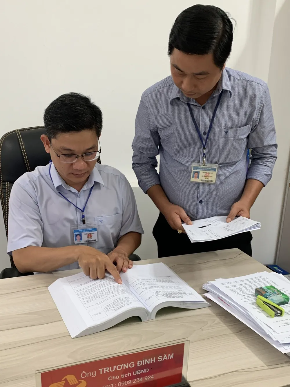 Ông Trương Đình Sâm (trái), Chủ tịch UBND phường 4, quận 8, cùng cán bộ UBND phường 4 tìm hiểu Bộ tài liệu phân tích công việc của UBND phường và chủ tịch UBND phường